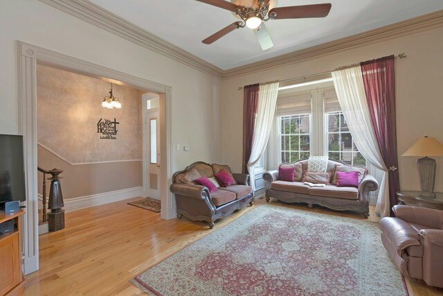 91 Sherman Pl, Jersey City, NJ 07307 - living area featuring light wood-type flooring, baseboards, a chandelier, a ceiling fan, and crown molding