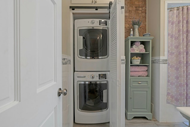 91 Sherman Pl, Jersey City, NJ 07307 - laundry area featuring estacked washer and dryer, tile walls, and wainscoting