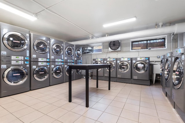 washroom featuring washing machine and clothes dryer, stacked washer / drying machine, and light tile patterned floors