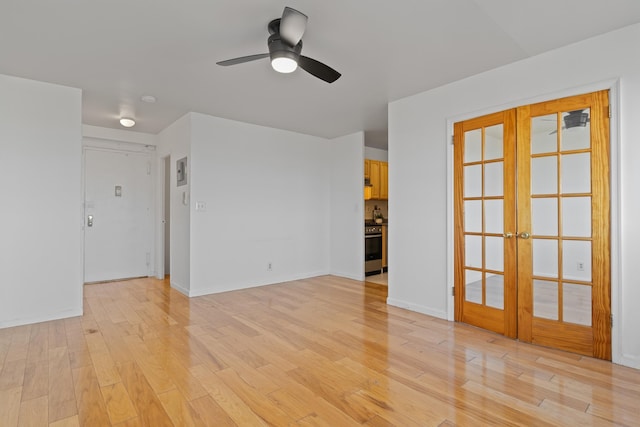 spare room featuring french doors, ceiling fan, and light wood-type flooring