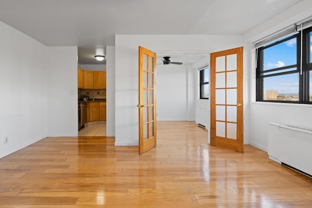 spare room featuring french doors and light hardwood / wood-style floors