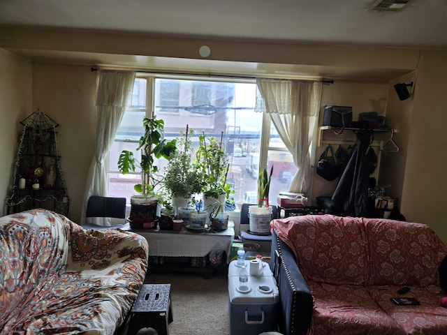 living area with visible vents and carpet