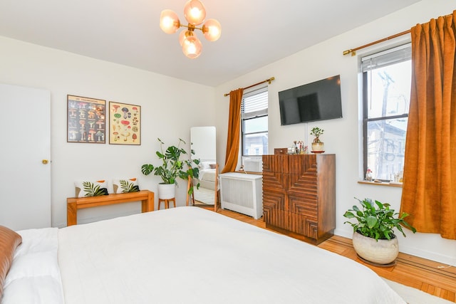 29 51st St Unit B5, Weehawken, NJ 07086 - bedroom with radiator heating unit, a chandelier, and wood finished floors