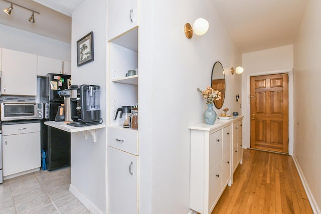 29 51st St Unit B5, Weehawken, NJ 07086 - kitchen with white cabinets, freestanding refrigerator, light countertops, and light wood-style floors