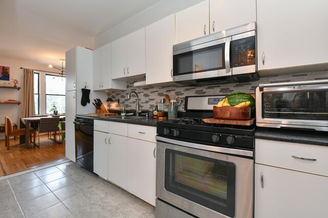 29 51st St Unit B5, Weehawken, NJ 07086 - kitchen with stainless steel appliances, tasteful backsplash, white cabinetry, and dark countertops
