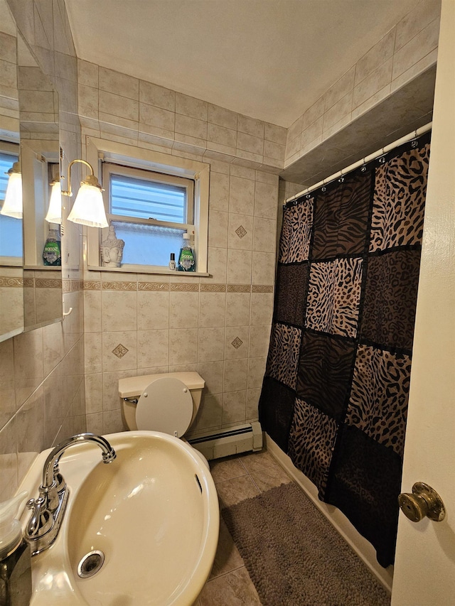 bathroom featuring sink, baseboard heating, a shower with curtain, tile patterned flooring, and tile walls