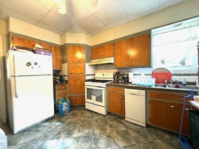 kitchen with white appliances, ceiling fan, a paneled ceiling, and backsplash