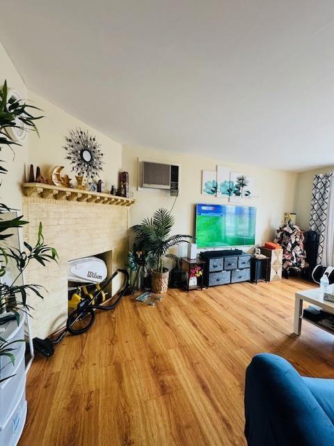 living room with hardwood / wood-style floors and an AC wall unit