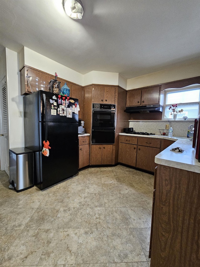 kitchen with tasteful backsplash, dark brown cabinets, and black appliances