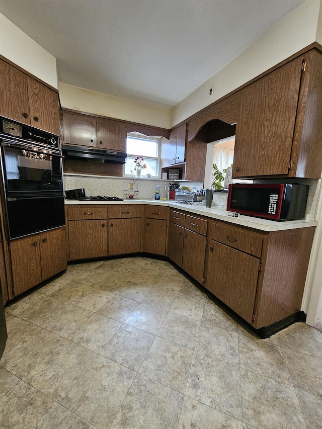 kitchen with backsplash, dark brown cabinetry, and gas cooktop