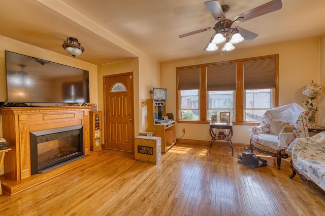159 W 33rd St, Bayonne, NJ 07002 - living room with light wood-style floors, a glass covered fireplace, ceiling fan, and baseboards
