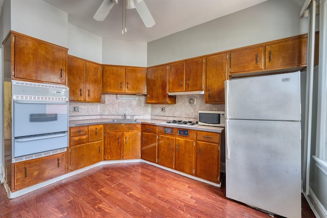 159 W 33rd St, Bayonne, NJ 07002 - kitchen with white appliances, a warming drawer, a sink, and brown cabinets