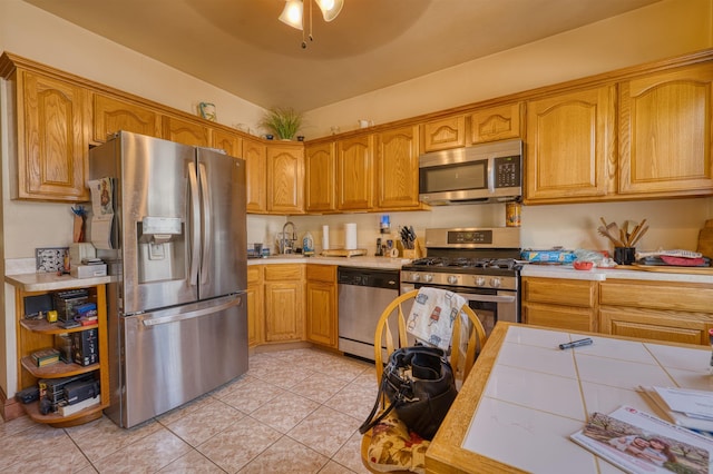 159 W 33rd St, Bayonne, NJ 07002 - kitchen featuring appliances with stainless steel finishes, light countertops, light tile patterned flooring, a sink, and brown cabinets