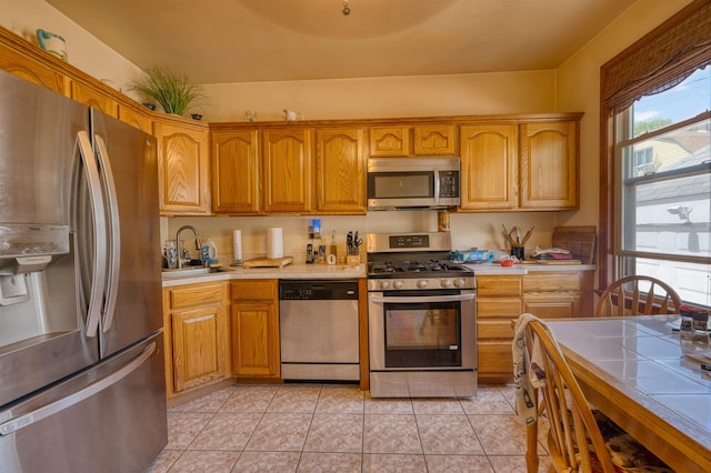 159 W 33rd St, Bayonne, NJ 07002 - kitchen featuring appliances with stainless steel finishes, a sink, light tile patterned flooring, and brown cabinetry