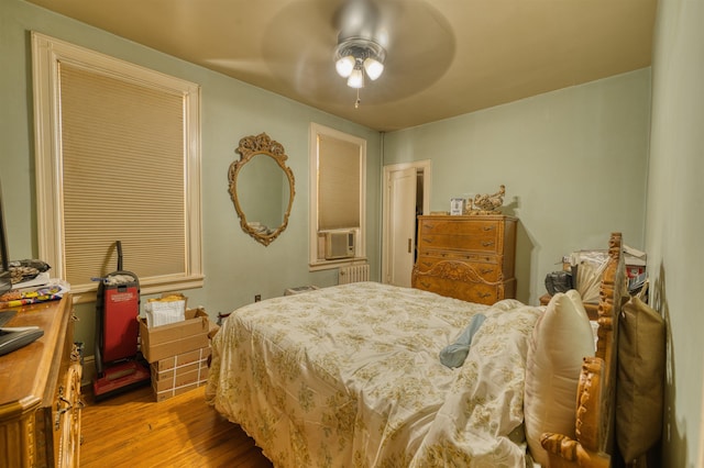 159 W 33rd St, Bayonne, NJ 07002 - bedroom with wood finished floors, radiator, ceiling fan, and cooling unit