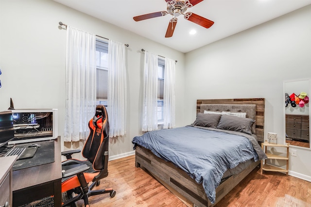 bedroom featuring a ceiling fan, baseboards, and wood finished floors