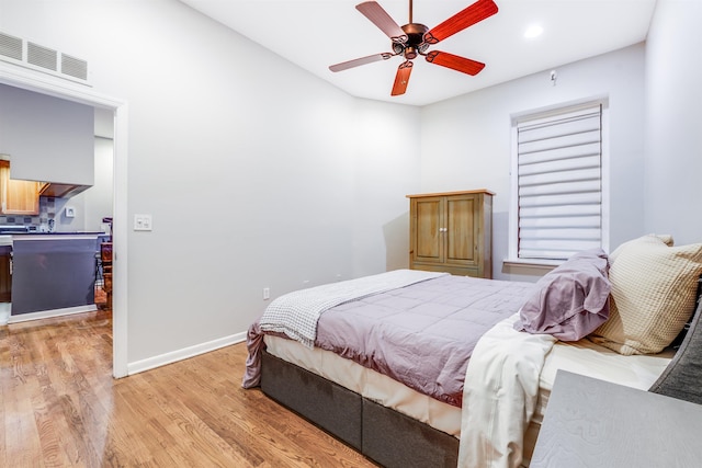 bedroom with ceiling fan, light wood-type flooring, visible vents, and baseboards