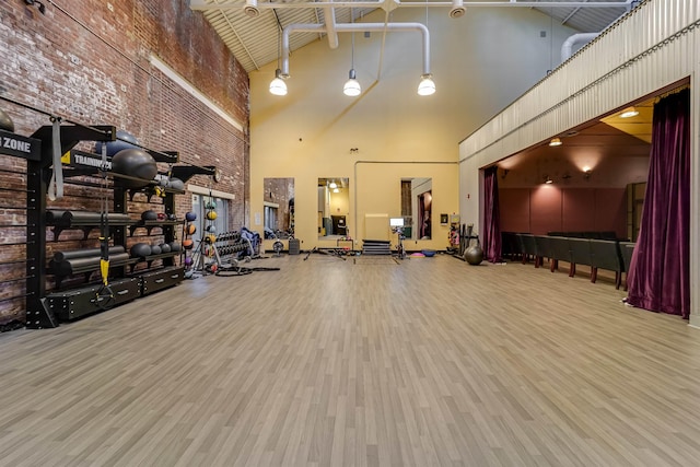 workout area with a towering ceiling and wood finished floors