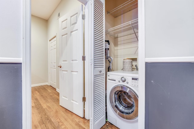 washroom featuring laundry area, visible vents, baseboards, washer / clothes dryer, and light wood-type flooring