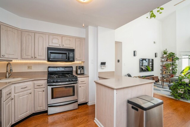 4313 Smith Ave Unit 10, North Bergen, NJ 07047 - kitchen with stainless steel gas range, black microwave, a sink, backsplash, and light countertops