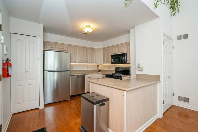 4313 Smith Ave Unit 10, North Bergen, NJ 07047 - kitchen with black appliances, a peninsula, a sink, and light wood finished floors