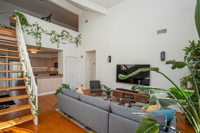 4313 Smith Ave Unit 10, North Bergen, NJ 07047 - living area featuring stairway, high vaulted ceiling, wood finished floors, and baseboards