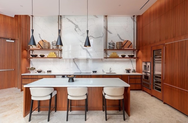 kitchen featuring pendant lighting, a center island, a kitchen bar, and sink