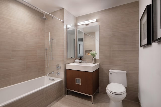 full bathroom featuring toilet, vanity, tile walls, and tiled shower / bath