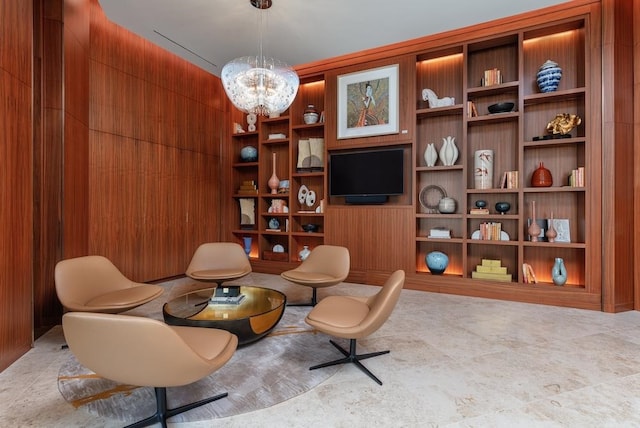 living area featuring wood walls, built in features, and a chandelier