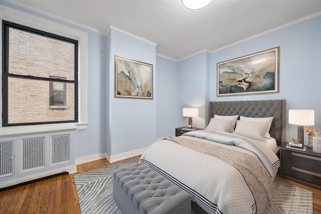 bedroom featuring radiator, crown molding, wood-type flooring, and multiple windows