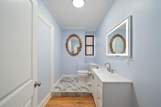 bathroom with hardwood / wood-style floors, vanity, toilet, and ornamental molding