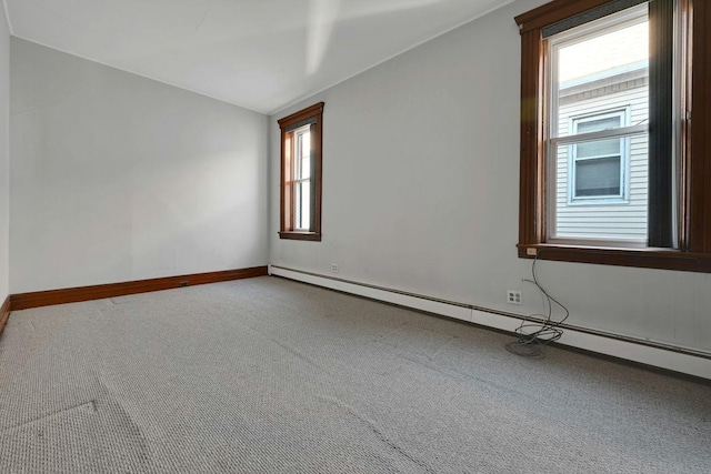 unfurnished room featuring a baseboard heating unit, vaulted ceiling, baseboards, and carpet floors