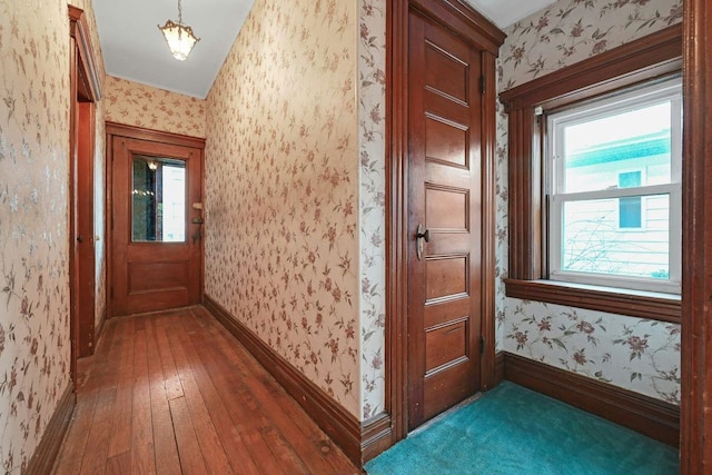 hallway featuring wallpapered walls, baseboards, and hardwood / wood-style floors