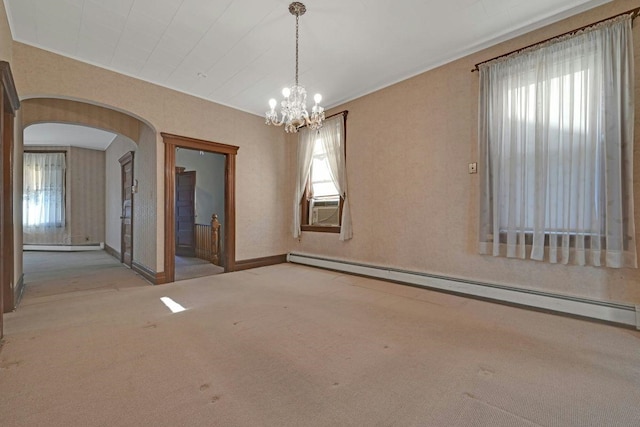 carpeted empty room featuring ornamental molding, cooling unit, arched walkways, baseboard heating, and a chandelier