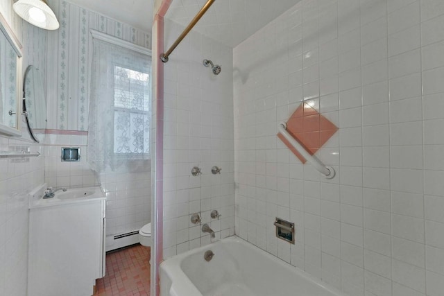 bathroom featuring washtub / shower combination, wallpapered walls, tile walls, toilet, and baseboard heating