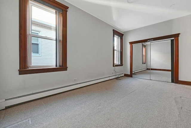 unfurnished bedroom featuring a closet, light carpet, baseboard heating, and baseboards