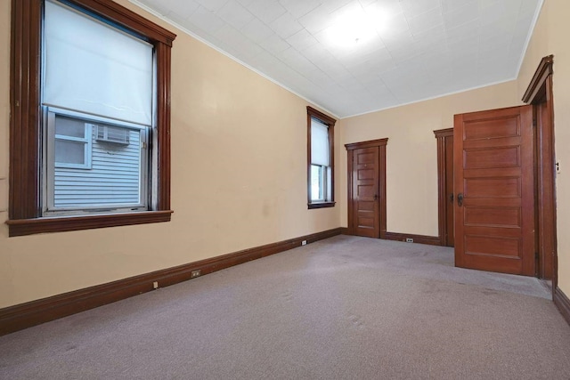 carpeted empty room with crown molding and baseboards