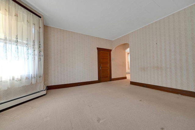 carpeted empty room featuring a baseboard radiator, arched walkways, baseboards, and wallpapered walls