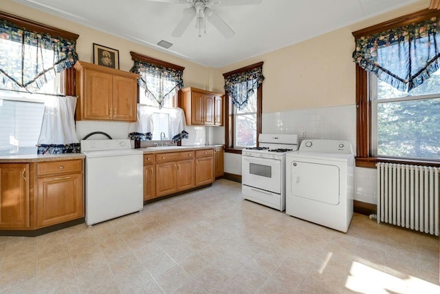 kitchen featuring washer / clothes dryer, radiator heating unit, gas range gas stove, and a sink