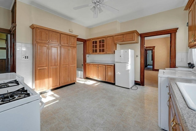 kitchen with glass insert cabinets, white appliances, a ceiling fan, and light countertops