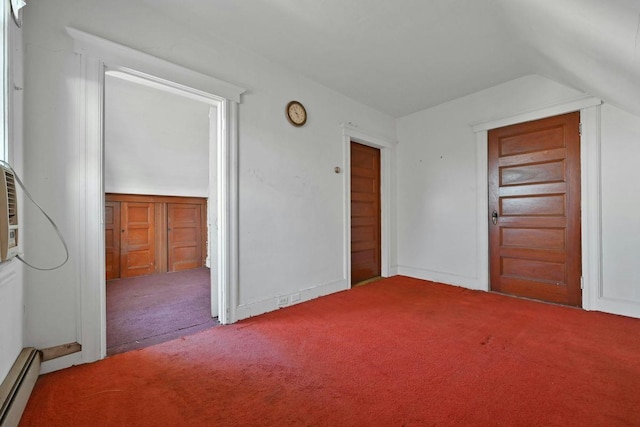 unfurnished bedroom featuring baseboard heating, carpet flooring, and vaulted ceiling