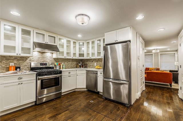 kitchen with tasteful backsplash, white cabinetry, dark hardwood / wood-style floors, and appliances with stainless steel finishes