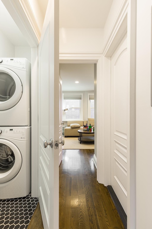 washroom featuring dark hardwood / wood-style flooring and stacked washer and clothes dryer