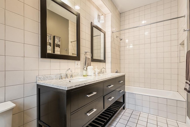 bathroom featuring tile patterned flooring, vanity, tile walls, and tiled shower / bath combo