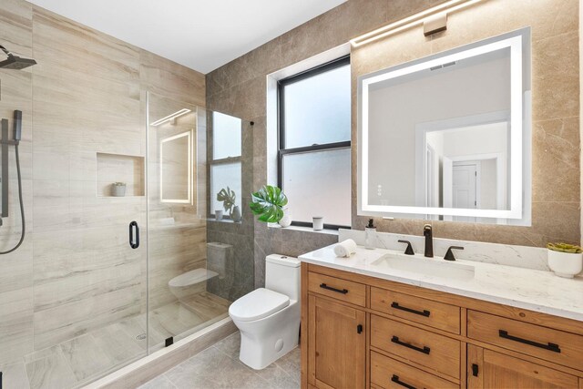 249 Bergen Ave Unit 201, Jersey City, NJ 07304 - full bathroom featuring tile walls, toilet, vanity, a shower stall, and tile patterned floors
