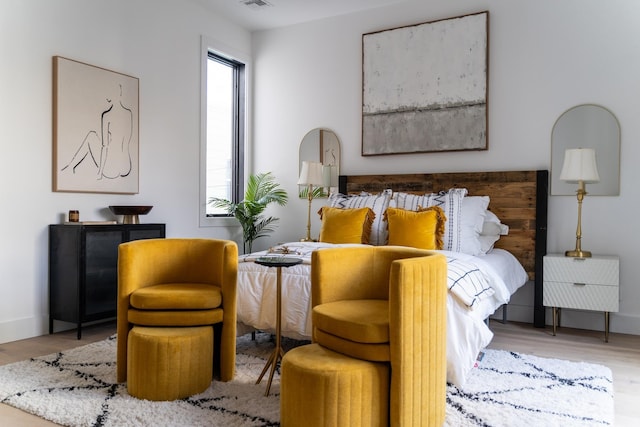 bedroom with visible vents, baseboards, and wood finished floors