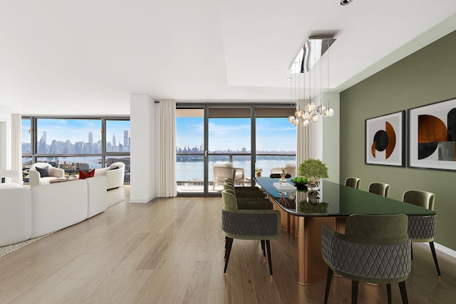 380 Mountain Rd Unit 1906-1907, Union City, NJ 07087 - dining room featuring expansive windows, wood finished floors, a chandelier, a water view, and plenty of natural light