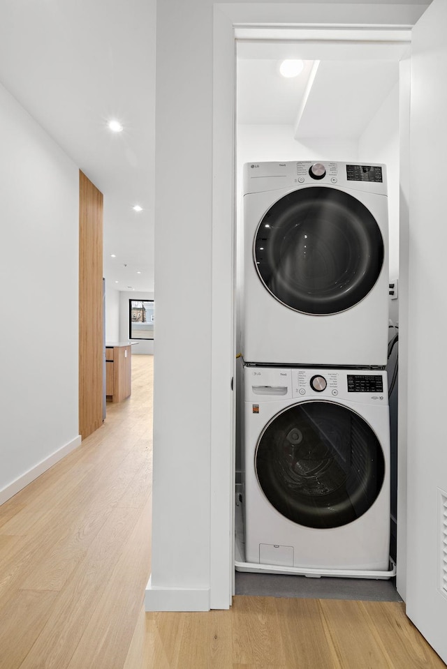 laundry room featuring stacked washer / drying machine, laundry area, recessed lighting, and wood finished floors