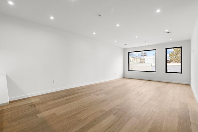 empty room featuring recessed lighting, visible vents, light wood-style flooring, and baseboards
