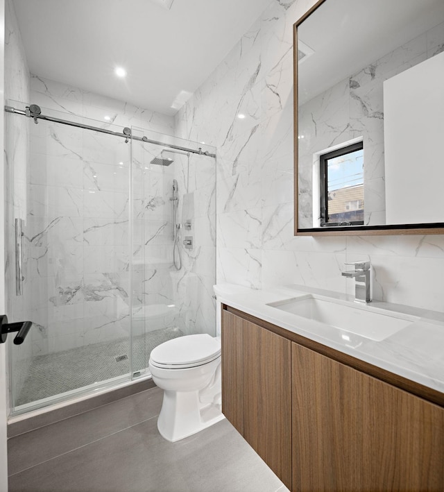 bathroom featuring toilet, a marble finish shower, tile walls, and vanity